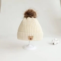 Cream knit baby hat with dark brown faux fur pompom and small bear leather patch - Bear Label Single Hat / Beige