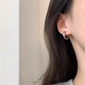 Polished silver metal hoop earrings shown on model for a minimalist aesthetic - Silver Chunky Ear Buckle