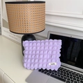Detail of purple textured bubble fabric makeup bag next to a laptop on an office desk - Bubble Light Purple