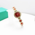 Dettaglio dell'orologio al quarzo dorato con quadrante rosso e strass incastonati - Rosso