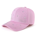 Detailed macro view of pink baseball cap featuring dense rhinestones and rainbow star accents - Pink