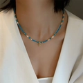 Baroque pearl bracelet with blue stone beads and golden heart pendant on model's neck - Natural Turquoise Pinecone Heart Necklace