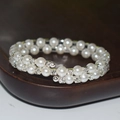 Detailed close-up of double-layer spiral bracelet with white pearls and sparkling rhinestones - 2 Rows Silver