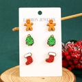Detailed close-up of Christmas stud earrings set with gingerbread man and festive tree - Wood Gingerbread Man Style