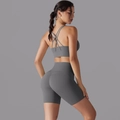 Dettaglio del set pantaloncini da yoga grigi a vita alta e reggiseno sportivo incrociato - Grigio titanio