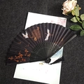 Classic Chinese folding fan with white crane pattern, black bamboo frame and tassel - Crane in Clouds