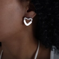 Irregular heart-shaped stud earrings in silver and white enamel worn by a model - White/Silver