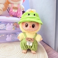 Plush doll wearing a green dinosaur outfit with overall pants and matching hat - Green Dinosaur Hat + Green Checkered Overalls / First And Second Generation Keychains Are Compatible With La Cloth Dolls. Dolls Not Included.