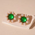 Close-up of vintage flower earrings with green resin center and pearl petals on stone tray - Green Pearl Flower Stud Earrings