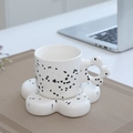 White ceramic coffee cup set with black splatter and flower handle in a cozy desk setting - Flower Cup & Saucer - Ink Splatter Black