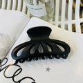 Detail of large matte black petal hair claw clip on magazine for elegant hairstyling - Matte Black