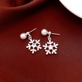 Detalle macro de pendientes de copo de nieve plateados con perla y circón en rojo - Copo de Nieve Blanco con Pin de Plata
