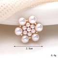 Makroaufnahme von 2,5 cm Perlenblumen-Charm mit goldener Basis auf weißem Stoff - D2411 13-Perlen-Blume