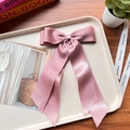 Pink satin double-layered bow hair clip displayed on a tray with a wooden background - Bean Pink 26
