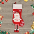 Kerstsok met 3D Kerstman pop voorzien van gestreepte benen op houten achtergrond - Kerstman