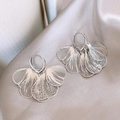 Elegantes pendientes de aro plateados con borlas de alas sobre tela de seda champán - Aro de Pétalo Hueco / Estilo Plateado