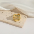 Detailed view of adjustable golden wide-band ring with braided texture and tiny zircons - Twist Braided