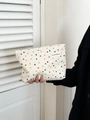 Cream canvas cosmetic bag with colorful polka dots held by a model in a black suit - Large White Polka Dot