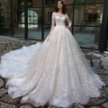 Close-up of elegant long-sleeve lace wedding dress with ball gown skirt and long train - US 2 / White