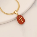 Macro shot of gold snake chain with a red natural stone pendant featuring a cross - Red Stone