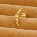 Close-up of golden curved seven-bead cartilage stud earring with a secure screw ball back - Gradient Seven Ball Arc