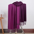 Detail view of purple cashmere scarf with tassels hanging on a display stand - No.16 Dark Purple