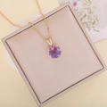 Close-up of a gradient purple faceted glass pendant on a delicate gold wave chain - Purple
