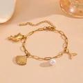 Detail of gold seashell and dolphin charms on a pearl beach style paperclip bracelet - Shell Dolphin Beach Bracelet (T706)