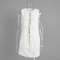 Dettaglio del completo bianco due pezzi con top senza maniche a fiocchi e minigonna a trapezio - S / Bianco
