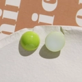 Detailed macro of glossy green and matte yellow resin beads on a ceramic plate - Fruit Green Round