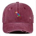Close-up of parrot embroidery and distressed details on a burgundy washed baseball cap - Burgundy
