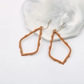 European style matte orange alloy hollow teardrop earrings on a marble base - Camel