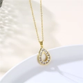 Macro shot of gold teardrop pendant with clear cubic zirconia pavé and hollow center - Gold
