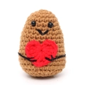 Close-up of a handmade crochet potato doll holding a red heart on a white background - Dark Brown Potato With Black Lines Holding A Heart