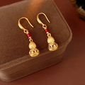 Vista macro de pendientes de calabaza en oro cepillado con detalles de esmalte rojo - Gancho de oreja - Dorado (Chapado en oro real)
