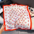 Detailed view of cherry print square silk scarf on white faux fur with elegant accessories - 70*70cm / Red Border Cherry