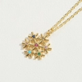 Detailed close-up of a golden snowflake necklace with vibrant multicolor gemstones on a white background - Colorful Zirconia Snowflake