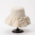 Detailed view of cream wide-brim sun hat featuring elegant wavy texture and a large bow - M(56-58cm) / Off White
