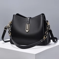 Elegant black lychee texture shell bag with gold hardware on white display pedestal - Black