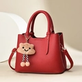 Détail d'un sac à main rouge en cuir PU texturé avec un charmant pendentif nuage en peluche - Bordeaux
