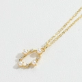 Collana a cuore dorata con perle bianche e diamanti brillanti su sfondo testurizzato - Stile Perla Cava Geometrica