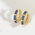 Macro detail of gold hoop earrings featuring four horizontal blue baguette cut stones - Royal Blue Zirconia (ES2833-2)