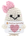 Macro detail of hand-knitted beige potato doll with a small pink bow and German message card - German Potato with Large Bow