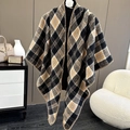 Detail of knit plaid shawl with V-neckline and decorative stitching on a black mannequin - Yellow Plaid