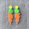 Detail of neon acrylic earrings with fluorescent lightning bolt charms on linen background - Orange Lightning
