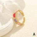 Makroaufnahme vergoldeter offener Ring mit roten und violetten Emaille-Herzmustern - Einstellbar Offen / Goldenes buntes Herz