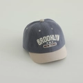 Dettaglio cappellino bimbo in velluto a coste blu-grigio con ricamo BROOKLYN e visiera - 50cm (1-3 anni) / Serie New York-Blu