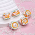 Macro shot of colorful hand-painted oil beads for DIY jewelry and beaded pens - White Bead + Green Edge Orange Cream + Pink Heart