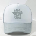 Blue and white mesh trucker hat with Good Things Take Time print on a stone stand - Gray