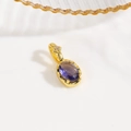 Detailed macro view of an 18k gold turtle pendant featuring a purple oval zircon stone - Oval Cut Gemstone Pendant / Purple (Oval Style)